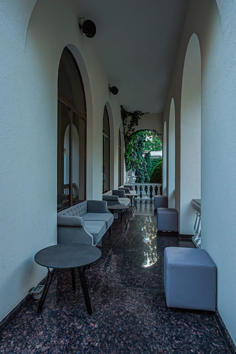 Zona lounge MiaDora cu canapele, plante și tavan din lemn, la apus