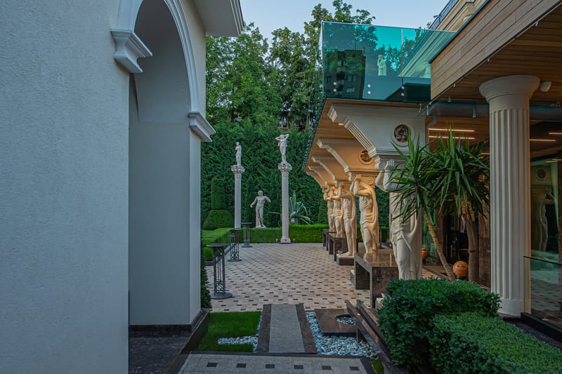 Fațada clasică MiaDora cu cariatide, coloane și balcon de sticlă, la apus