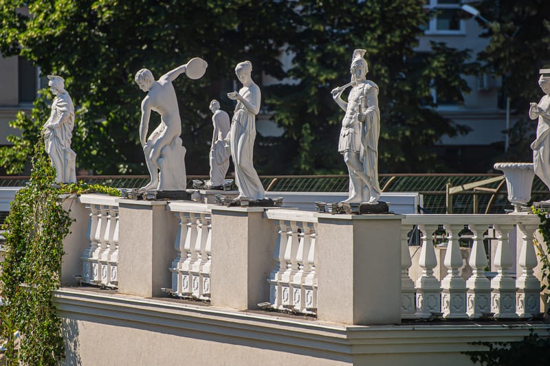 Detaliu arhitectural MiaDora: statui pe balustrada acoperișului, în lumina zilei